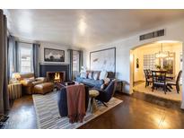 Living room with fireplace, comfortable seating, and view of dining area at 533 W Lewis Ave, Phoenix, AZ 85003