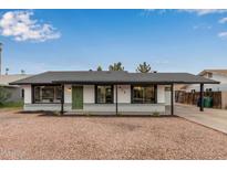 Charming single story home with a green door and gravel driveway at 615 W Enid Ave, Mesa, AZ 85210