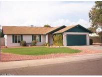 Single-story home with green door and well-maintained lawn at 6820 W Cameron Dr, Peoria, AZ 85345