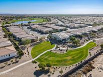 Aerial view showcasing a community with a lake, golf course, and numerous homes at 86 E Iloca Ln, Queen Creek, AZ 85140