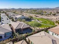 Aerial view of a residential community with a park and mountains in the background at 86 E Iloca Ln, Queen Creek, AZ 85140