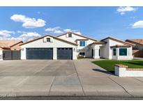 White two-story house with a three-car garage and manicured lawn at 8740 W Bloomfield Rd, Peoria, AZ 85381