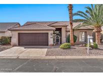 Single-story home with a brown garage door and desert landscaping at 15653 W Monterey Way, Goodyear, AZ 85395