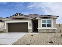 Charming single-story home featuring a two-car garage and neutral-toned stucco with brick accents at 1587 S 239Th Dr, Buckeye, AZ 85326