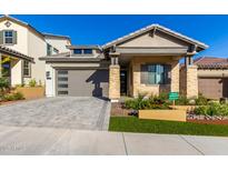 Craftsman style home with stone exterior, gray garage door, and landscaped front yard at 16611 S 9Th St, Phoenix, AZ 85048