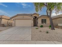 Tan house with a two-car garage and landscaped front yard at 3257 W Five Mile Peak Dr, San Tan Valley, AZ 85144