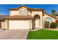 Two-story house with a beige exterior, two-car garage, and landscaped lawn at 4250 E Towne Ln, Gilbert, AZ 85234