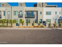 Modern townhomes featuring neutral stucco, black framed windows, and small balconies at 4354 N 27Th Pl, Phoenix, AZ 85016