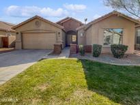 Single-story home with two-car garage and well-maintained lawn at 4421 W Pleasant Ln, Laveen, AZ 85339