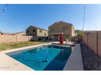 Inviting backyard oasis with a sparkling pool and patio area at 5496 S 237Th Ln, Buckeye, AZ 85326