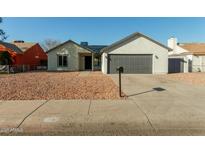 Newly renovated single-story home with a modern gray garage door at 7602 W Minnezona Ave, Phoenix, AZ 85033