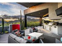 Inviting covered outdoor space with comfortable seating, built-in grill and stunning mountain views at 11541 E Salero Dr, Scottsdale, AZ 85262