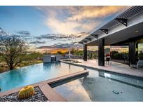 Luxury pool and spa with mountain views at sunset at 11541 E Salero Dr, Scottsdale, AZ 85262