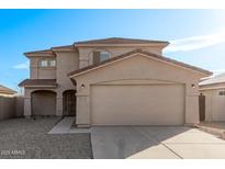 Two-story house with beige exterior, two-car garage, and landscaped front yard at 16765 W Hadley St, Goodyear, AZ 85338