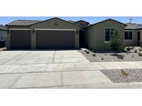 New home exterior featuring a two-car garage and attractive landscaping at 17299 W Dahlia Dr, Surprise, AZ 85388