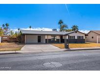 Charming single-story home with a well-maintained yard, covered parking and gray color scheme at 1839 E Indigo St, Mesa, AZ 85203