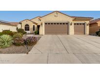 Tan two-story house with a three-car garage and landscaped front yard at 20359 N 262Nd Dr, Buckeye, AZ 85396