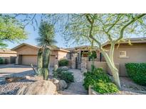 Desert landscaping accents this single-story home's stucco exterior, highlighting a charming entrance at 211 E Desert Wind Dr, Phoenix, AZ 85048