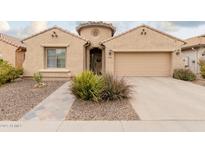 Tan house with a two-car garage and landscaped front yard at 2528 W Brookhart Way, Phoenix, AZ 85085