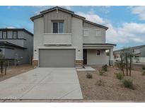 Two-story home with gray siding, two-car garage, and landscaped yard at 2575 E Bluff Spring Ave, Apache Junction, AZ 85119