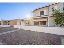 Two-story house with white brick and gray siding, a small front yard, and a gate at 2929 E Broadway Rd # 13, Mesa, AZ 85204