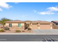 Single-story home with stone accents and a three-car garage at 5758 W Kowalsky Ln, Laveen, AZ 85339