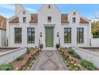 Stunning white brick home with a green door, landscaped walkway, and flowerbeds at 6737 E Exeter Blvd, Scottsdale, AZ 85251