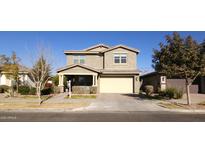 Two-story house with tan siding, attached garage, and landscaping at 9750 E Radioactive Dr, Mesa, AZ 85212