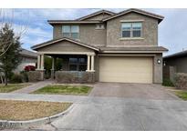 Two-story house with beige exterior, attached garage, and landscaping at 9750 E Radioactive Dr, Mesa, AZ 85212