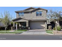 Charming two-story home featuring a well-manicured lawn and welcoming front porch at 9750 E Radioactive Dr, Mesa, AZ 85212