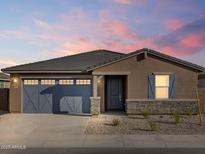 Charming single-story home showcasing a stylish blue garage door and complementary stone accents at 37358 W San Clemente St, Maricopa, AZ 85138