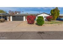 Charming single story home with landscaped front yard and modern garage door at 6808 E Loma Land Dr, Scottsdale, AZ 85257