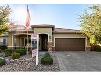 Single-story house with a brown garage door and well-maintained landscaping at 11047 E Tupelo Ave, Mesa, AZ 85212