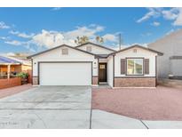 Newly built home with white siding, brick accents, and a two-car garage at 1217 S Desert View Pl, Apache Junction, AZ 85120