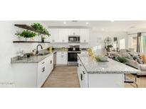 Modern kitchen with white cabinets, granite counters, and a large island at 1217 S Desert View Pl, Apache Junction, AZ 85120