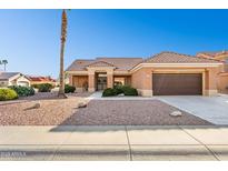 Tan house with brown roof, desert landscaping, and a two-car garage at 14203 W Rico Dr, Sun City West, AZ 85375