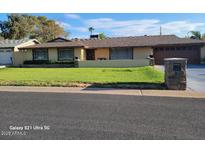 Ranch style home with landscaped lawn, attached garage, and driveway at 1707 E Mclellan Blvd, Phoenix, AZ 85016