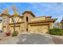 Beige stucco two-story home with a three-car garage and landscaping at 21320 N 56Th St # 2043, Phoenix, AZ 85054