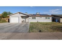 House exterior featuring a two-car garage and solar panels at 3440 W Krall St, Phoenix, AZ 85017