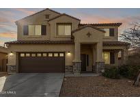 Two-story house with a brown double garage door and stone accents at 39979 W Robbins Dr, Maricopa, AZ 85138