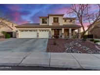 Two-story house with three-car garage, landscaping, and a rock garden at 7409 W Briles Rd, Peoria, AZ 85383