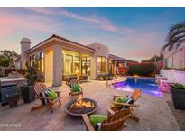 Luxury backyard oasis with a sparkling pool, fire pit, and comfortable seating at 8260 E Mohawk Ln, Scottsdale, AZ 85255