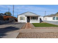 Front yard view of a renovated home with brick driveway at 1614 W Lynwood St, Phoenix, AZ 85007