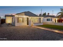 Charming bungalow with a brick driveway, walkway, and artificial turf at 1614 W Lynwood St, Phoenix, AZ 85007