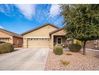One-story house with tan exterior, two-car garage, and landscaping at 22568 W Gardenia Dr, Buckeye, AZ 85326