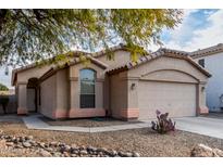 Beige house with a two-car garage and desert landscaping at 2625 N 110Th Dr, Avondale, AZ 85392