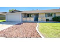 Brick ranch home with a 1-car garage, well-manicured lawn, and a gravel driveway at 9841 N Balboa Dr, Sun City, AZ 85351