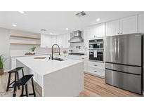 Modern kitchen with white cabinets, stainless steel appliances, and large island at 1010 E Indianola Ave, Phoenix, AZ 85014