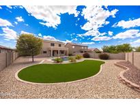 A spacious backyard with green lawn, a pool, beautiful gravel work, and desert landscaping at 12503 S 175Th Ave, Goodyear, AZ 85338
