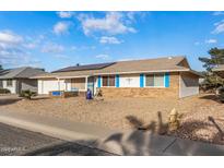 Ranch-style home with solar panels, landscaped yard, and blue accents at 12630 W Crystal Lake Dr, Sun City West, AZ 85375